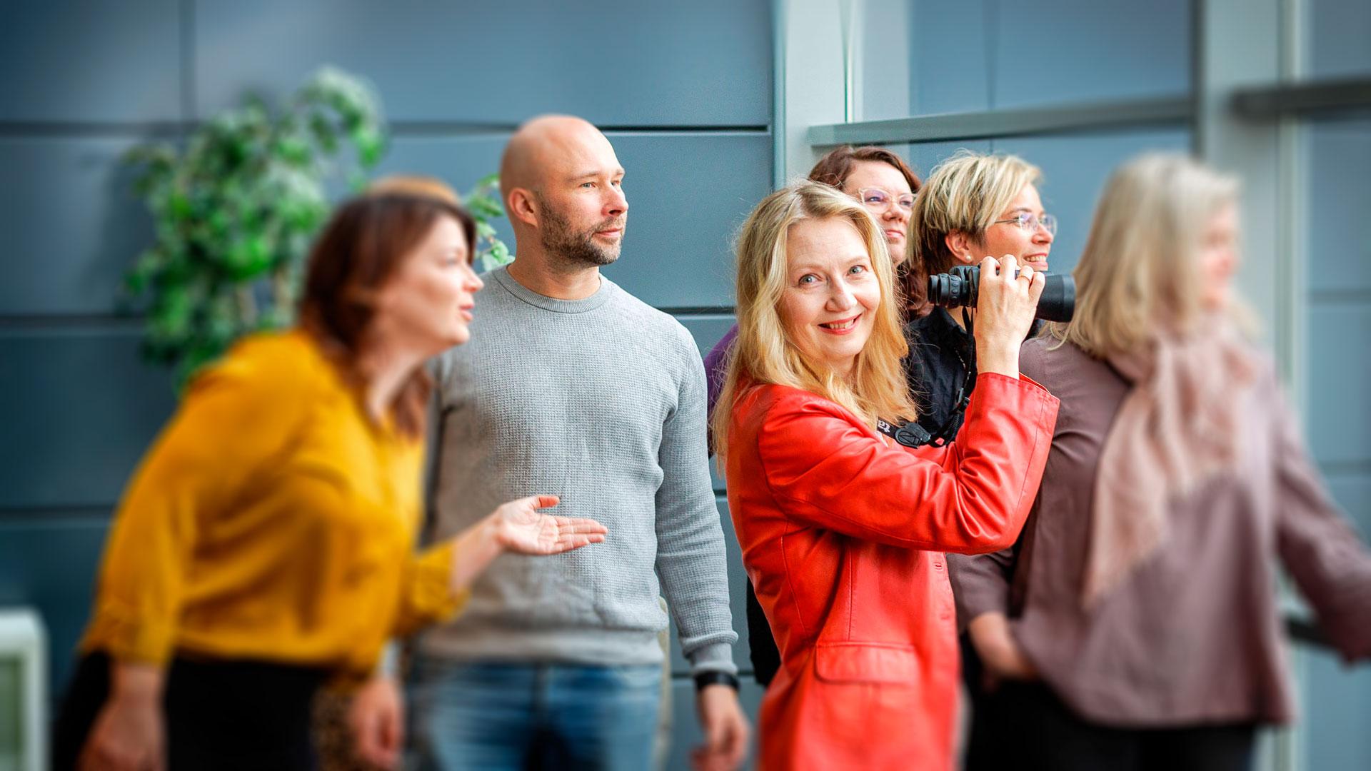 Pomopaketti-valmennus. Esimies innostaa porukkaa onnistumaan. Hymyilevä työntekijäjoukko.