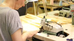 Ompelija tekee töitään Etelä-Pohjanmaalla. Ompelukoneen ääressä nainen ompelee tuotetta. Ompelu vaatii tarkkuutta.