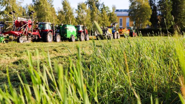 Vihreä pelto ja maatalouskoneita.