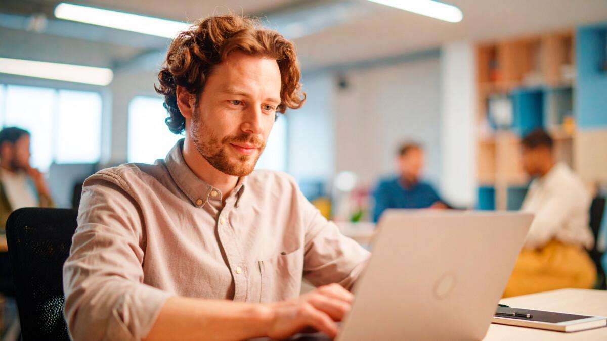 Mies läppärillä osallistumassa Suomen Yrittäjäopiston tietoturvaa ja dataosaamista käsittelevään webinaariin. Tekoälykuva.