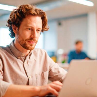 Mies läppärillä osallistumassa Suomen Yrittäjäopiston tietoturvaa ja dataosaamista käsittelevään webinaariin. Tekoälykuva.