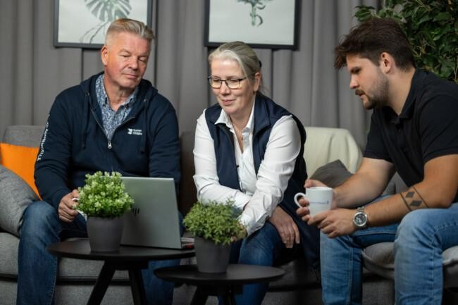 Maatalousyrittäjän taloustaidot -hanke. Kolme henkilöä keskustelee läppärin äärellä maataloudesa.