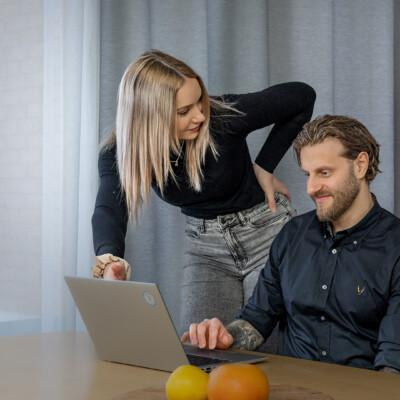 Kaksi henkilöä kannettavan tietokoneen edessä.