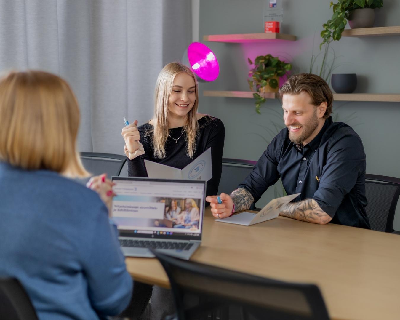 Henkilöitä keskustelemassa pöydän ympärillä TyöLakeus rekryyn hakeutumisesta.