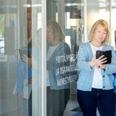 Kaksi naista katsoo yhdessä älypuhelimen näytöltä HR-asiantuntijan koulutuksen sisältöä.