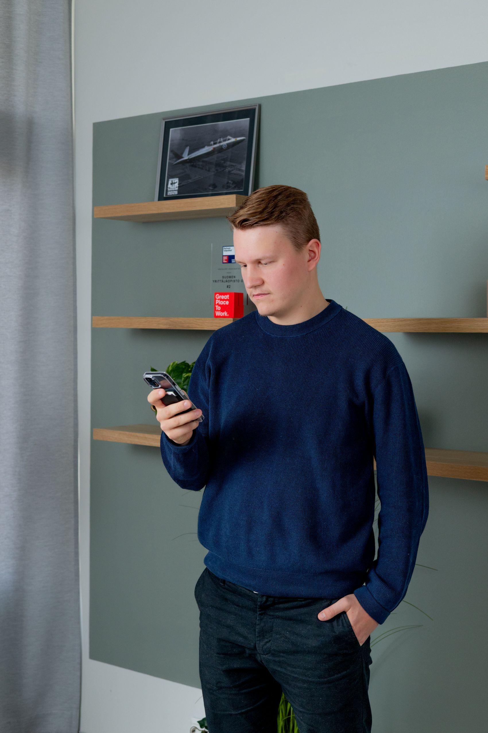 Henkilö tutustuu merkonomikoulutuksen toteutukseen puhelimelta.